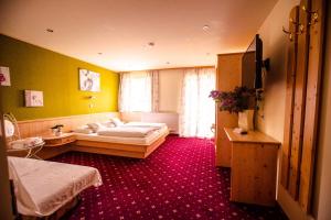 a hotel room with two beds and a red carpet at Hotel Wintergarten in Schladming