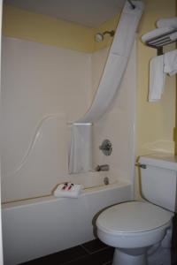 a bathroom with a toilet and a bathtub with a sink at Spark by Hilton Kodak in Kodak