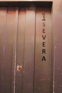 a metal door with a sign that reads sex valvearma at Casas de Fado in Lisbon