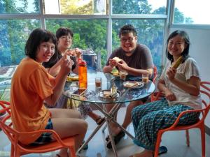 a group of people sitting around a table eating food at Bliss Guest House Assi Ghat in Varanasi