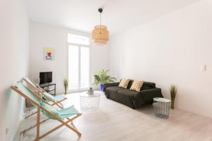 ein Wohnzimmer mit einem Sofa und einem Stuhl in der Unterkunft RELAXING 95m² DUPLEX APPARTEMENT 3 Chambres in Béziers