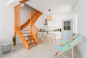 a staircase in a living room with chairs and a kitchen at RELAXING 95m² DUPLEX APPARTEMENT 3 Chambres in Béziers