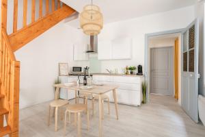 a kitchen with a wooden table and stools at RELAXING 95m² DUPLEX APPARTEMENT 3 Chambres in Béziers