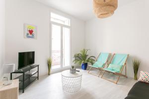 a living room with two chairs and a television at RELAXING 95m² DUPLEX APPARTEMENT 3 Chambres in Béziers +4 photos