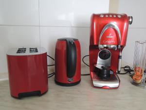 a red coffee maker and a toaster on a counter at Das alte Zinshaus in Knittelfeld