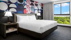 a hotel room with a bed and a large window at Studio Allston Hotel Boston in Boston