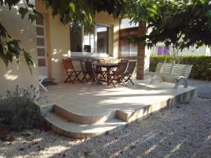 eine Terrasse mit einer Bank, einem Tisch und Stühlen in der Unterkunft Maison du Port in Narbonne-Plage