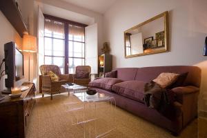 ein Wohnzimmer mit einem lila Sofa und einem TV in der Unterkunft Toreros de Sevilla 5 pax in Sevilla