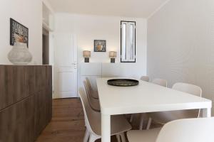 a white dining room with a white table and chairs at Santa Marta Deluxe by Homing in Lisbon