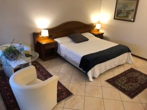 een slaapkamer met een bed, een bank en een stoel bij B&B Casa Boscolo in Piove di Sacco