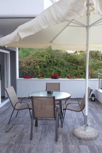 a table and chairs with an umbrella on a patio at Blue4Aqua Apartments in Kavála