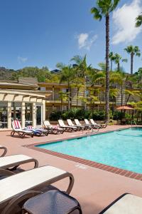 a resort swimming pool with lounge chairs and palm trees at Best Western Seven Seas in San Diego