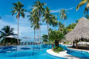 a pool at the resort with palm trees at Tango Mar Beachfront Boutique Hotel & Villas in Tambor