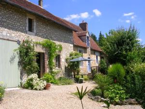 une maison avec un parasol dans une cour dans l'établissement la Maison des Aubées, à Rémalard