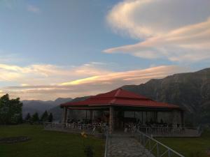 a pavilion with tables and chairs on a mountain at Hotel Tzoumerka in Pramanta