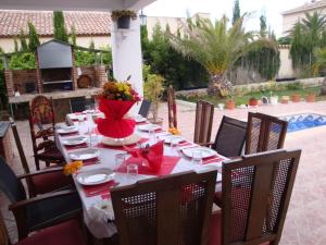 a table with red napkins and a vase of flowers on it at Casa del Arte in L'Ametlla de Mar