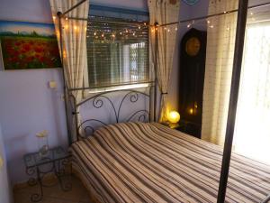 a bedroom with a canopy bed with a window at Casa del Arte in L'Ametlla de Mar +13 photos