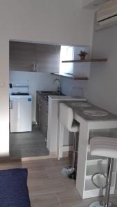 a kitchen with a table and a sink and a stove at Apartments Nives in Mali Lošinj