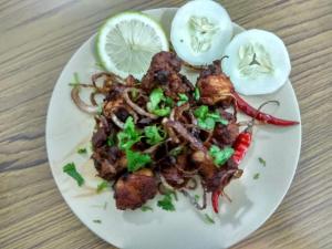 a plate of food with onions and meat on a table at Latei Ville Inn in Shillong