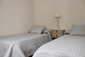 two beds sitting next to each other in a bedroom at Mi piso en la ría in Barreiros