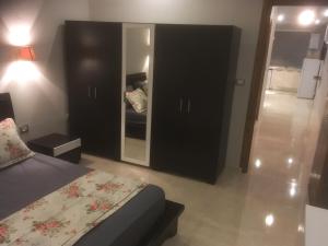 1 dormitorio con cama y espejo grande en London House en Bizerte