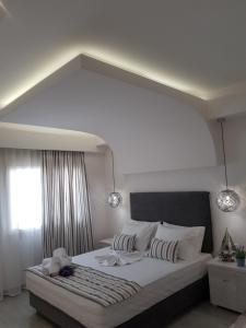 a bedroom with a large white bed with a large window at Metsikas Residence in Limenas