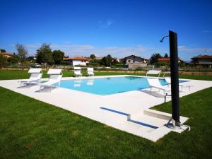 una piscina con sillas y un poste en el césped en Villa Montenero, en Cavalcaselle