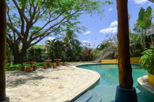 a swimming pool with picnic tables and trees at Luxury Studio Apartment with all the Trimmings in San Juan del Sur