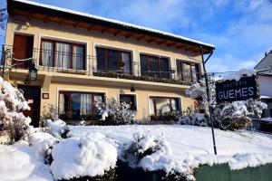 a house with a sign in the snow at Hostería Güemes in San Carlos de Bariloche