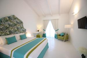 特罗佩阿Il Borghetto Resort & Spa的白色的客房配有一张床和椅子