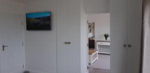 einen Flur mit einem weißen Zimmer mit einem Gemälde an der Wand in der Unterkunft Tidal View in Kincasslagh