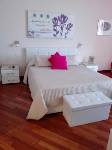 1 dormitorio con 1 cama blanca grande con almohada rosa en Residenza Piazza Moro, en Bari