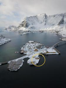 an aerial view of a harbor with snow covered mountains at Olstind in Sakrisøy in Reine