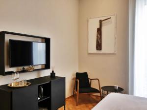 una camera con TV, letto e sedia di Palazzo Marina a Trani