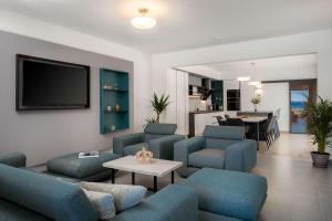 a living room with blue furniture and a tv at Villa Four Brothers - Middle Floor in Podstrana