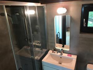 a bathroom with a sink and a shower and a mirror at KÉSA Faház in Balatonlelle +15 photos