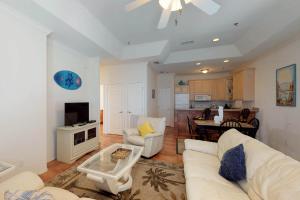 sala de estar con sofá blanco y cocina en Las Puertas 201 en South Padre Island