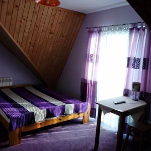 1 dormitorio con cama, mesa y ventana en Pokoje Gościnne Oliwka, en Poronin