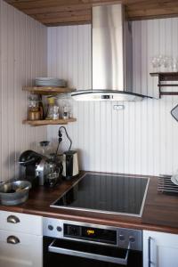 a kitchen with a stove top oven in a kitchen at MINI SAKRISØY Apartment in Reine