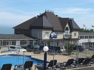 
a house that has a boat parked in front of it at Motel Vue Belvédère in Saint-Siméon
