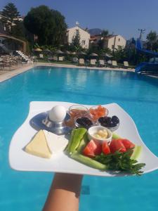 a plate of food on a tray in front of a swimming pool at Sayar Apart in Marmaris