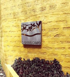 a sign on the side of a yellow wall at Hotel Casa en el Campo in Morelia