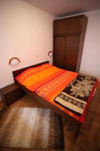 1 dormitorio con 1 cama y armario de madera en Family Apartments, en Žabljak