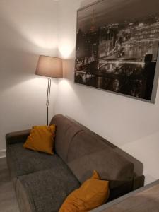 a couch in a living room with a picture on the wall at Comfy Parisian studio! in Ivry-sur-Seine