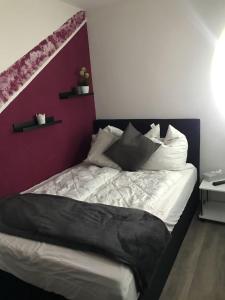 Schlafzimmer mit einem Bett mit lila Akzenten in der Unterkunft Hahnenklee Ferienpark 1-411 in Hahnenklee-Bockswiese