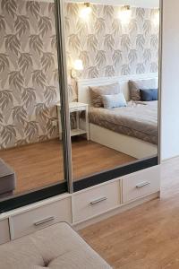 a mirror in a room with a bed and a table at Kraslava 2 Bedroom Lux Apartments in Krāslava