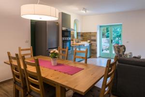 a kitchen and dining room with a wooden table and chairs at Villa Natura in Vrbnik