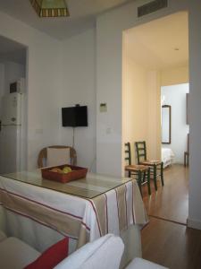 uma cozinha e sala de estar com mesa e cadeiras em Apartamento céntrico Plaza del Salvador em Sevilha