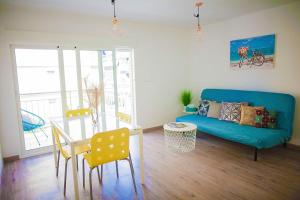 sala de estar con sofá azul y mesa de cristal en Apartment near the beach en Alicante