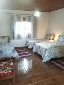 um quarto com 2 camas e uma janela em Pousada Caminho da Serra em Tiradentes